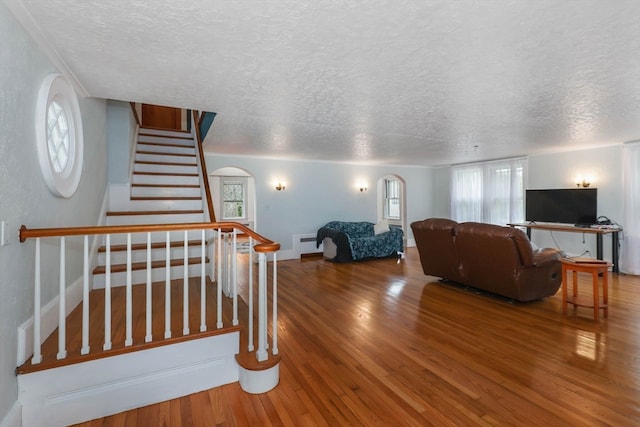 living room with a textured ceiling, wood-type flooring, and radiator heating unit