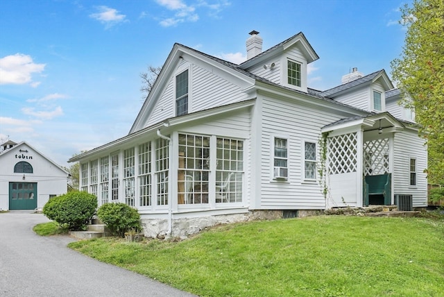 view of side of home featuring a garage and a yard