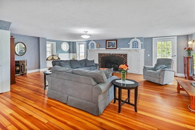 living room featuring light wood-type flooring and a brick fireplace