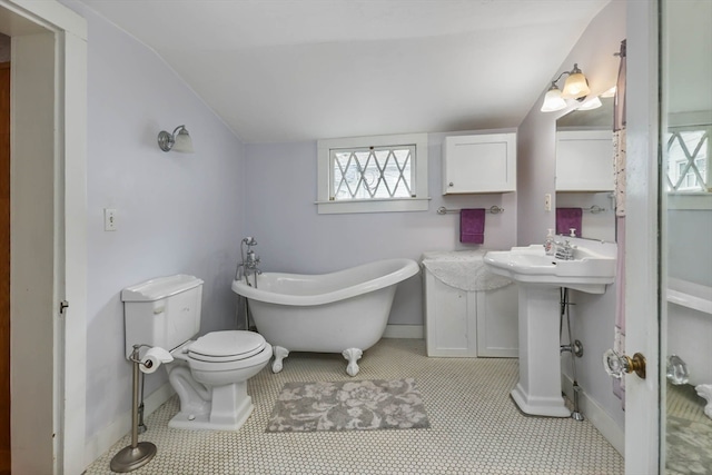 bathroom featuring a bath to relax in, toilet, tile floors, and lofted ceiling