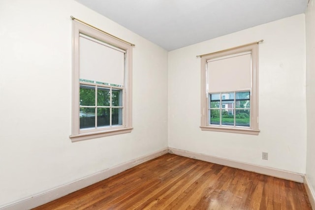 empty room featuring baseboards and wood finished floors