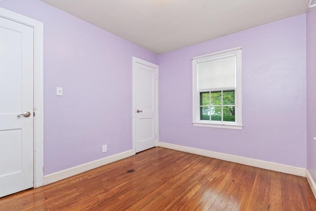 unfurnished room featuring baseboards and wood-type flooring