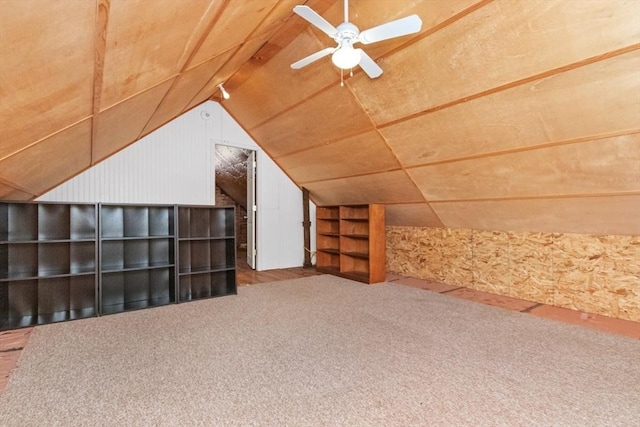 bonus room featuring carpet floors, lofted ceiling, wood walls, and ceiling fan