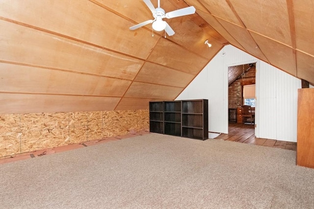 additional living space featuring vaulted ceiling, carpet, ceiling fan, and wood walls