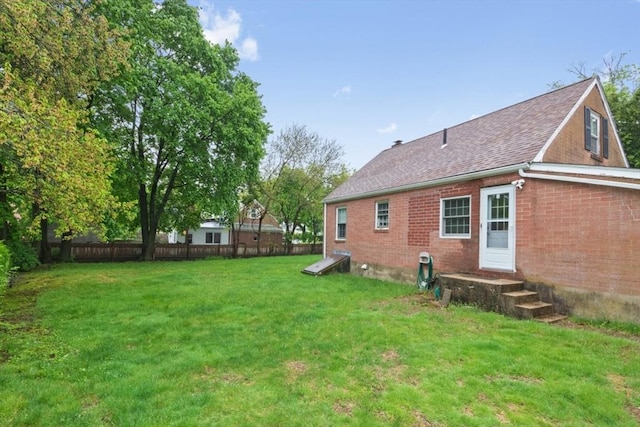 rear view of property featuring brick siding and a shingled roof