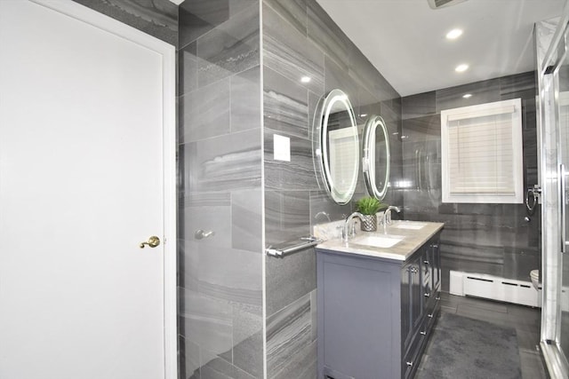 541 Grattan St, Chicopee, MA 01020 - bathroom featuring baseboard heating, double vanity, tile walls, recessed lighting, and a shower with shower door