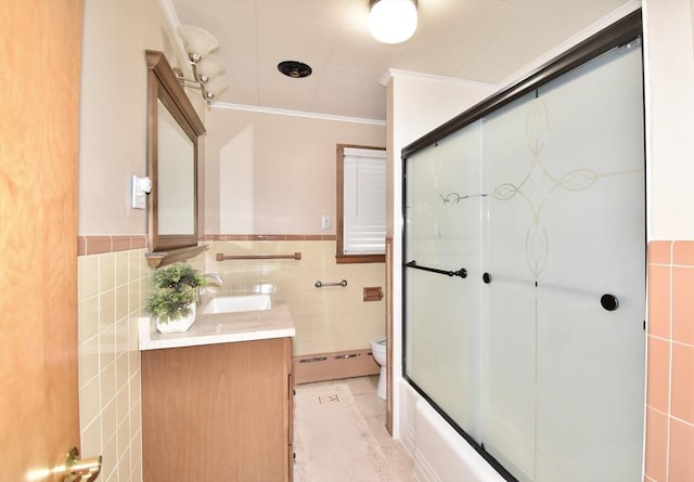541 Grattan St, Chicopee, MA 01020 - bathroom featuring vanity, tile walls, crown molding, a baseboard radiator, and combined bath / shower with glass door