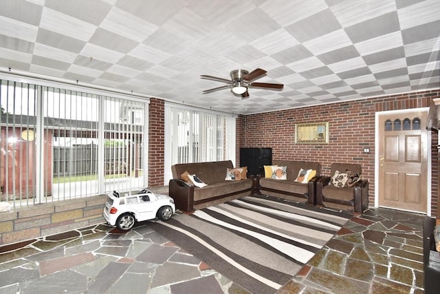 541 Grattan St, Chicopee, MA 01020 - living room featuring brick wall, stone flooring, and a ceiling fan