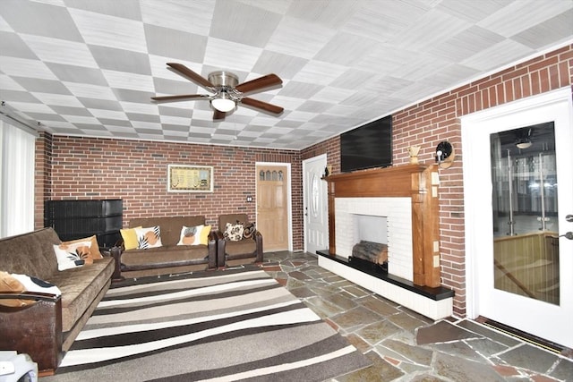 541 Grattan St, Chicopee, MA 01020 - living area featuring a brick fireplace, brick wall, stone tile floors, and ceiling fan