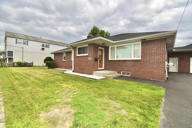 541 Grattan St, Chicopee, MA 01020 - view of front facade with brick siding, a front lawn, asphalt driveway, and a chimney