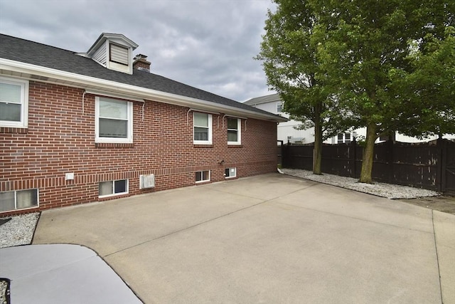 541 Grattan St, Chicopee, MA 01020 - view of home's exterior with a patio, brick siding, and roof with shingles