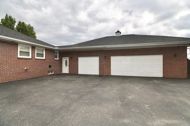 541 Grattan St, Chicopee, MA 01020 - view of side of home with asphalt driveway, an attached garage, brick siding, and a shingled roof