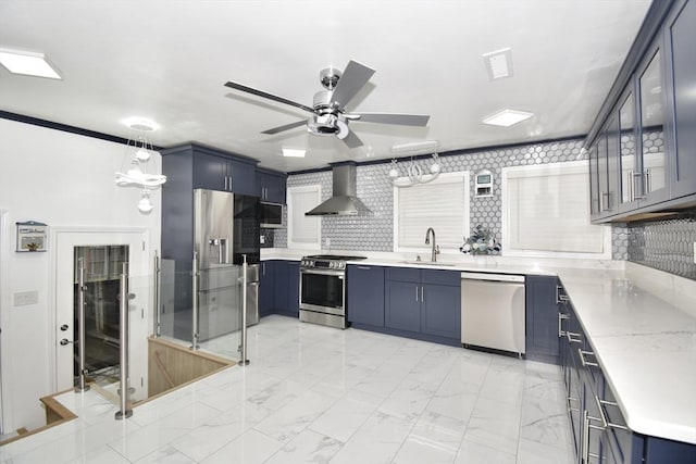 541 Grattan St, Chicopee, MA 01020 - kitchen featuring stainless steel appliances, wall chimney exhaust hood, blue cabinetry, a ceiling fan, and light marble finish flooring