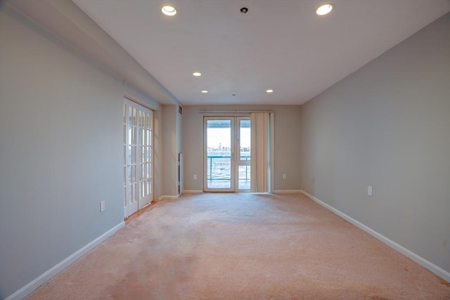 spare room with baseboards, light colored carpet, and recessed lighting