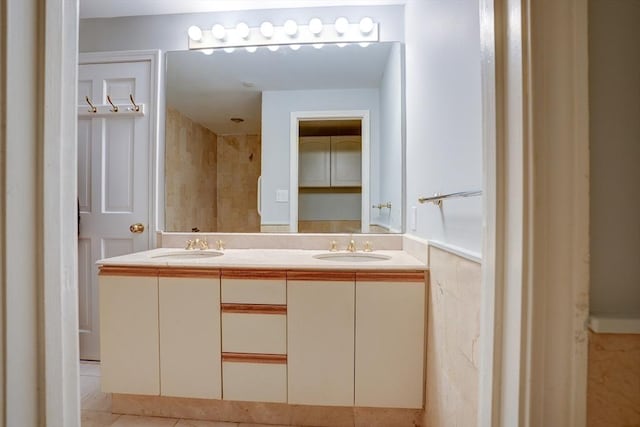 full bath with double vanity, a sink, and tile patterned floors