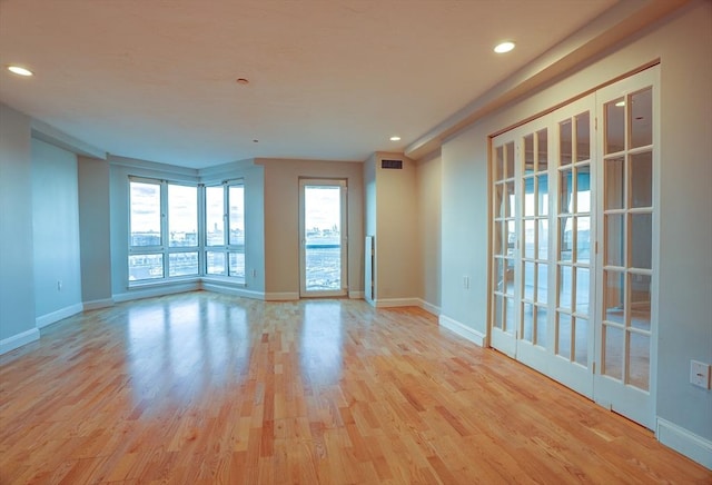 spare room with recessed lighting, wood finished floors, visible vents, and baseboards