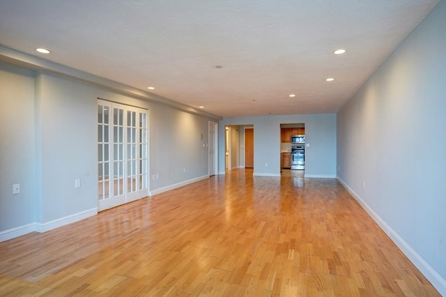 unfurnished room featuring recessed lighting, baseboards, and light wood finished floors