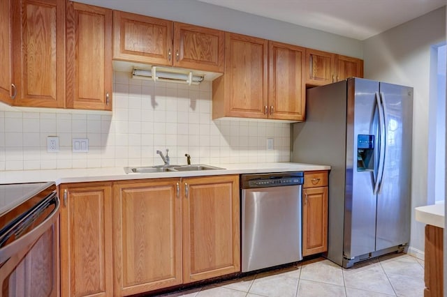 kitchen with light tile patterned floors, appliances with stainless steel finishes, light countertops, and a sink