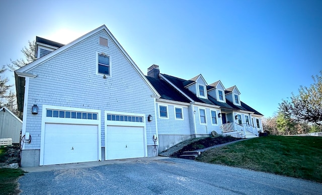 new england style home with a front lawn and a garage