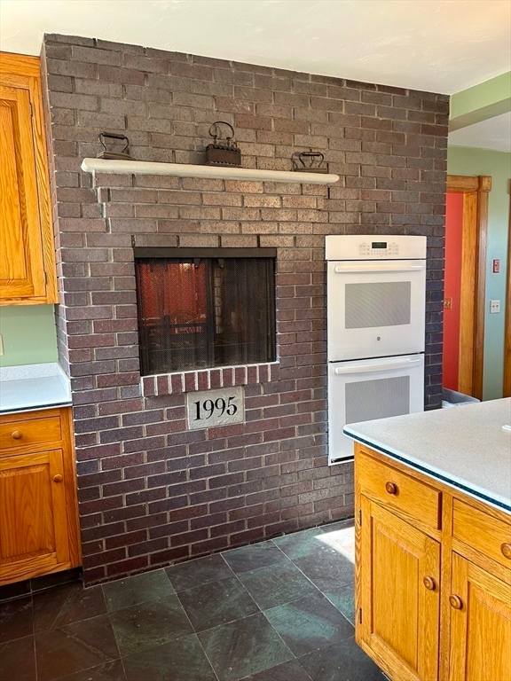 kitchen featuring double oven and a multi sided fireplace