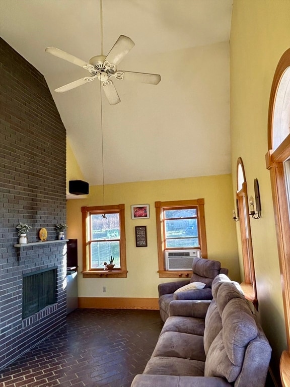 living room with ceiling fan, a healthy amount of sunlight, high vaulted ceiling, cooling unit, and a fireplace