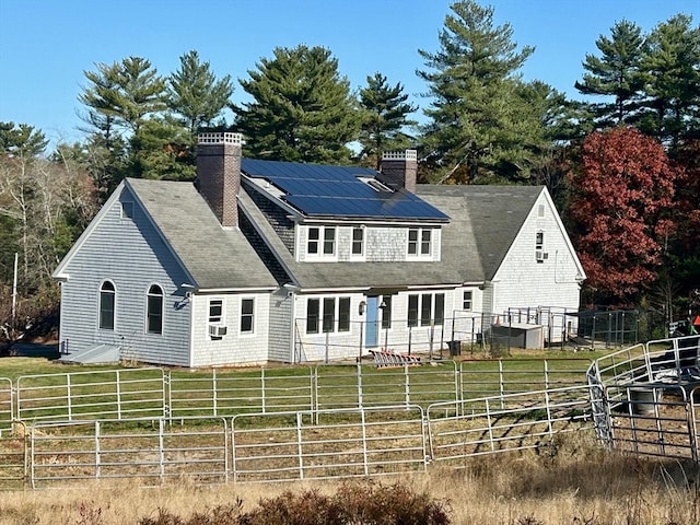 rear view of property featuring a lawn and a rural view