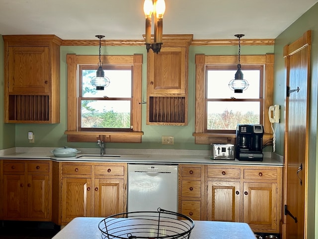 kitchen featuring white dishwasher, hanging light fixtures, and sink