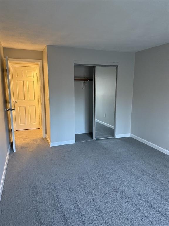 unfurnished bedroom with carpet floors and a closet