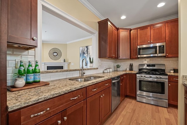 960 Main St Unit C, Woburn, MA 01801 - kitchen featuring stainless steel appliances, a sink, ornamental molding, backsplash, and light wood finished floors