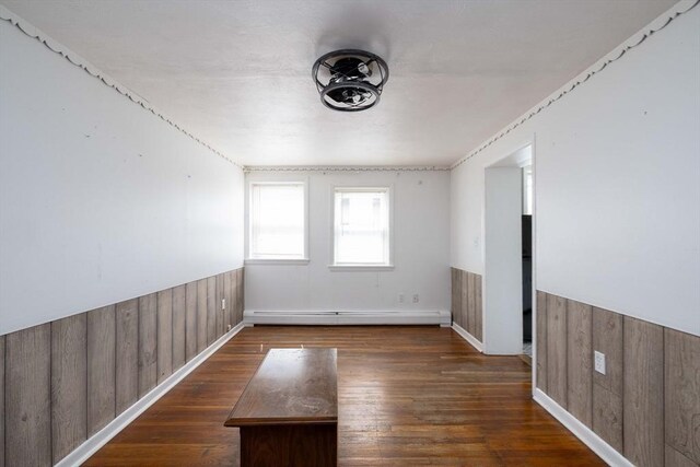 224-232 Caroline, New Bedford, MA 02740 - empty room with a baseboard radiator, a wainscoted wall, wooden walls, and hardwood / wood-style flooring
