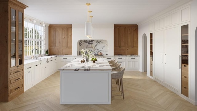 65 Temple Rd, Wellesley, MA 02482 - kitchen featuring a sink, arched walkways, a kitchen island, glass insert cabinets, and a kitchen bar