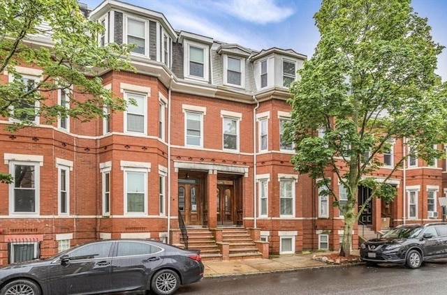 multi unit property with mansard roof and brick siding