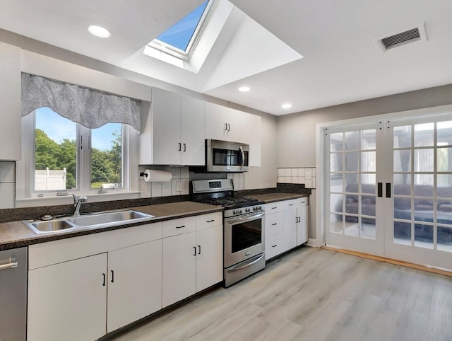 10 Vernon Ave, Hull, MA 02045 - kitchen with stainless steel appliances, dark countertops, light wood-style flooring, white cabinets, and recessed lighting