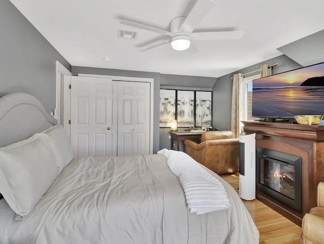 10 Vernon Ave, Hull, MA 02045 - bedroom with light wood-type flooring, a ceiling fan, a glass covered fireplace, and a closet