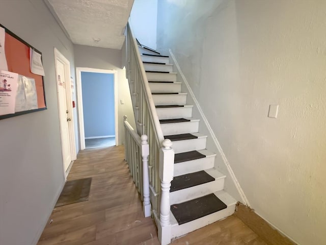 stairs featuring hardwood / wood-style floors