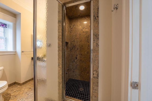 full bath featuring a stall shower, toilet, and baseboards