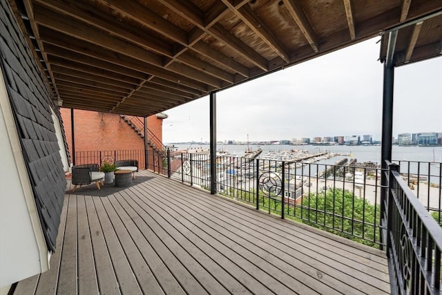 wooden terrace featuring a water view and a view of city