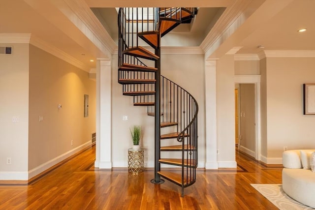 stairs featuring crown molding, baseboards, and wood finished floors