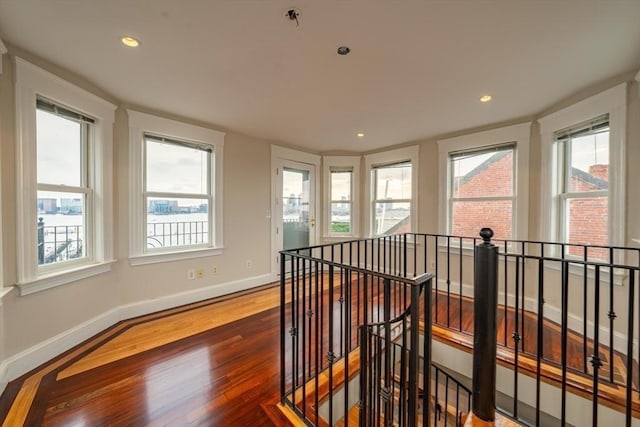 interior space featuring recessed lighting, baseboards, an upstairs landing, and wood finished floors