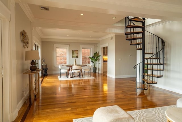 interior space with ornamental molding, wood finished floors, visible vents, and baseboards