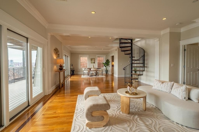 living area with a healthy amount of sunlight, stairway, ornamental molding, and light wood finished floors