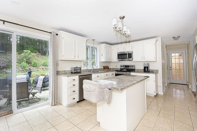 54 Clarke Rd, Sturbridge, MA 01518 - kitchen with appliances with stainless steel finishes, light tile patterned floors, white cabinetry, and a kitchen island