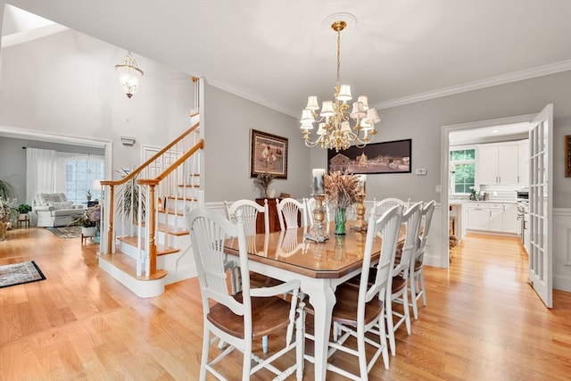 dining room featuring an inviting chandelier, ornamental molding, and light wood-type flooring