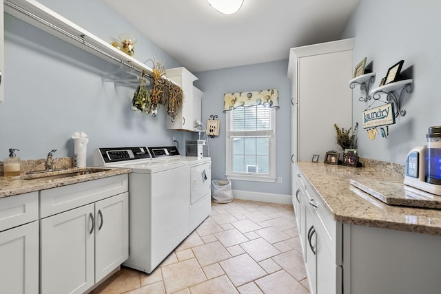 laundry area with cabinets, independent washer and dryer, and sink