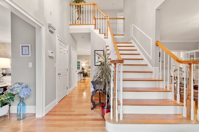 stairs featuring wood-type flooring and a high ceiling