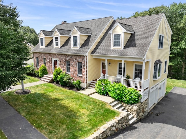 cape cod-style house with a front yard, a garage, and covered porch