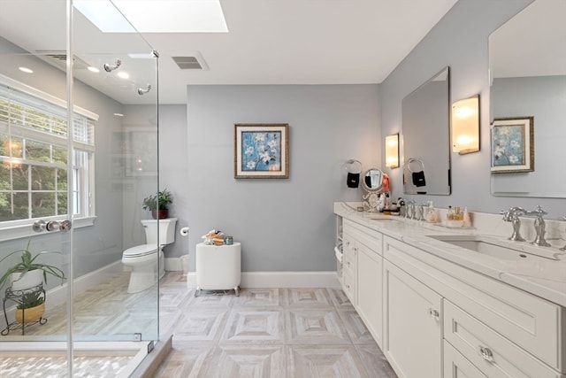 bathroom featuring vanity, toilet, walk in shower, and a skylight