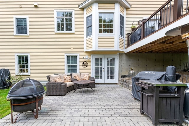 view of patio / terrace featuring a grill, an outdoor living space with a fire pit, a balcony, and french doors