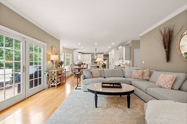 living room with crown molding, light hardwood / wood-style flooring, and french doors