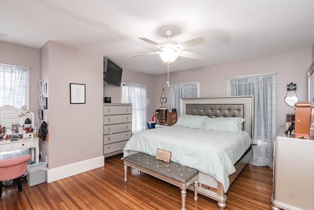 bedroom with ceiling fan, dark wood-type flooring, and multiple windows